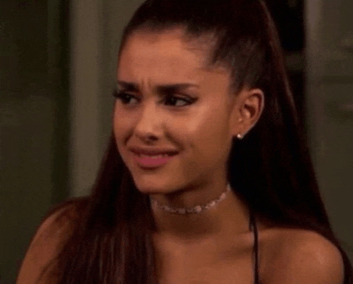ariana grande is making a funny face while wearing a choker necklace .