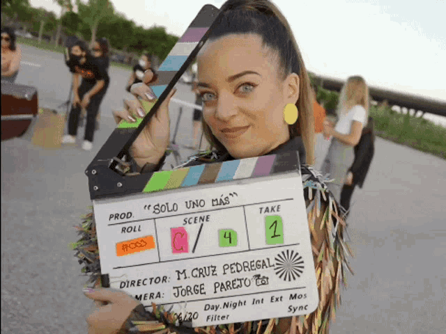 a woman holds up a clapper board that says solo uno mas