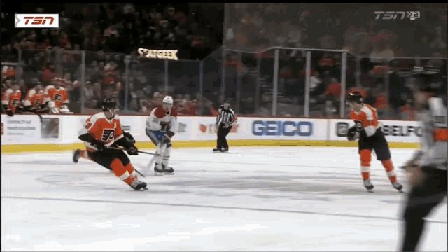 a hockey game is being played in front of a geico sign
