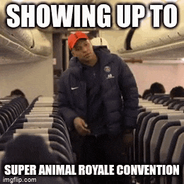 a man in a blue jacket and red hat is standing on an airplane .