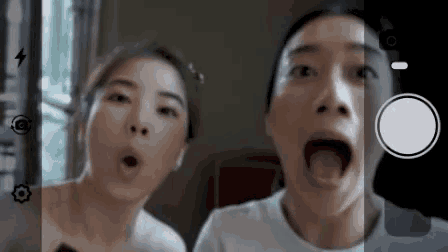 two women with their mouths open are being photographed