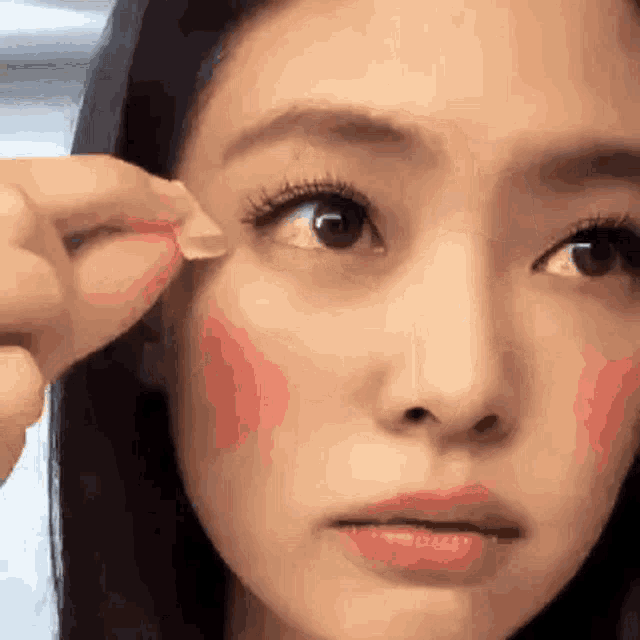 a close up of a woman 's face with a sticker on it .
