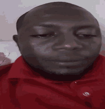 a man in a red shirt is making a funny face with his mouth wide open .