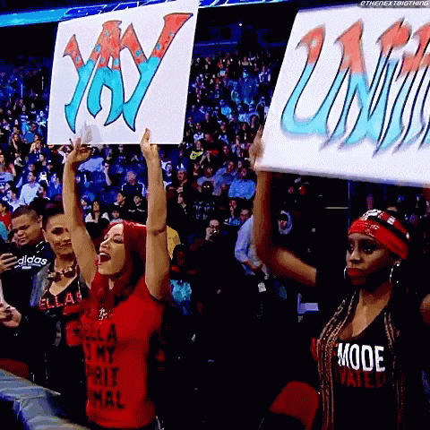 a woman in a red shirt is holding up a sign that says " yay "