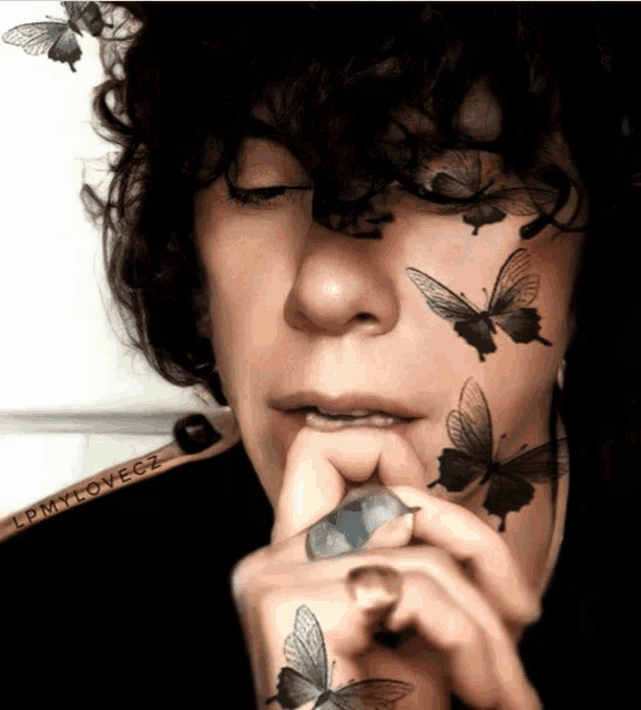a person with butterflies on their face has a sticker that says epmylovegz