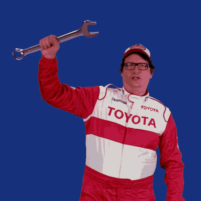 a man in a toyota uniform is holding up a wrench