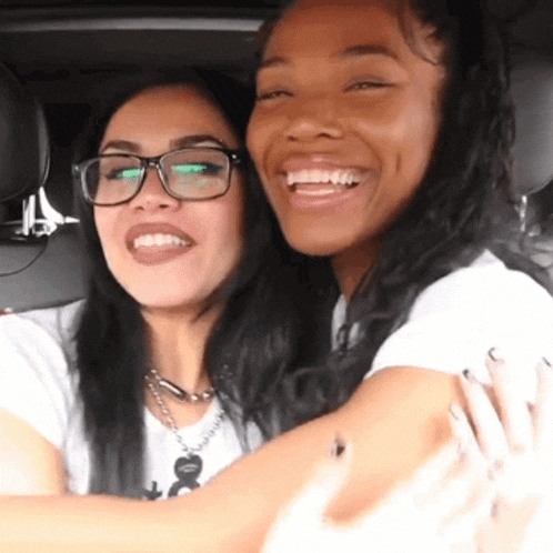 a woman wearing glasses is smiling next to another woman wearing glasses