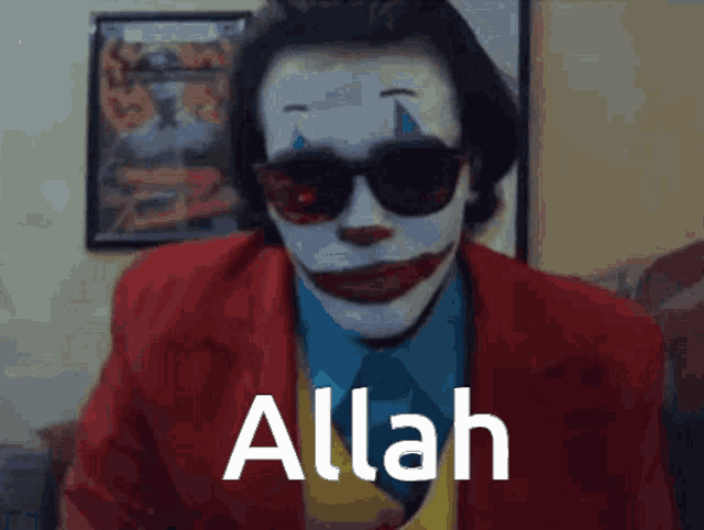 a man dressed as the joker is wearing sunglasses and has the word allah above him