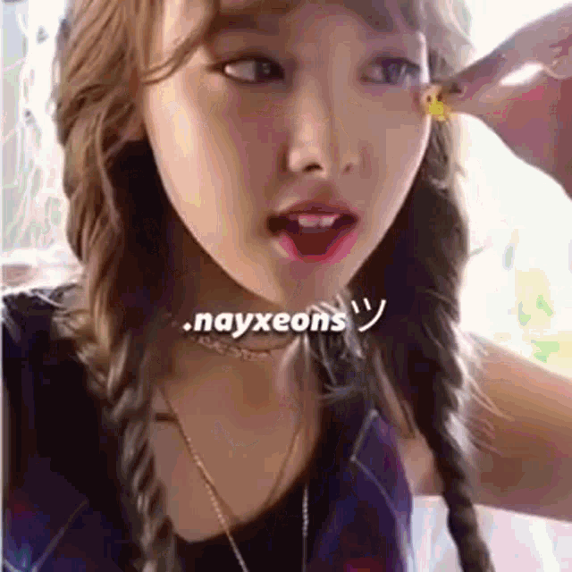 a close up of a woman 's face with the words `` nayxeons '' written on it .