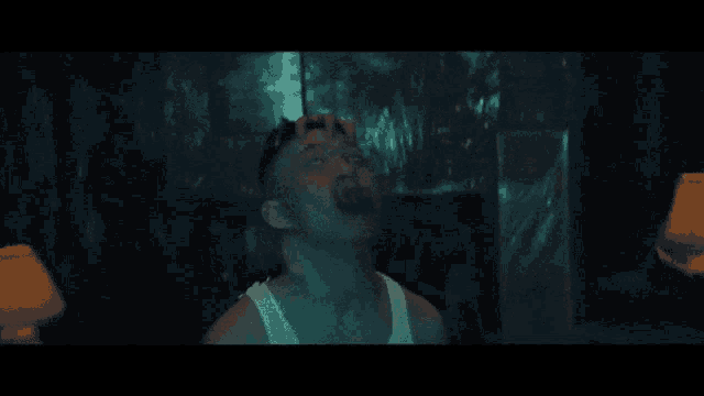 a man is smoking a cigarette in a dark room