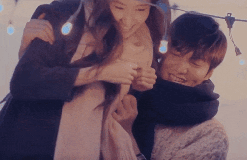 a man and a woman are hugging each other and smiling