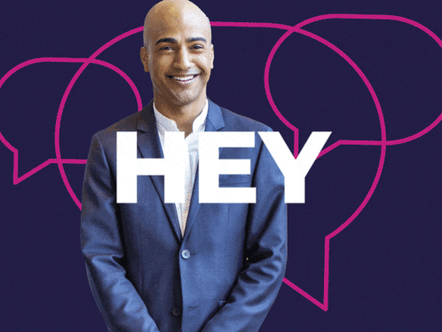 a man in a suit stands in front of a yellow background with the word hey on it