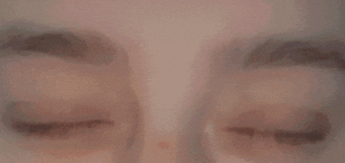 a close up of a person 's eyes with blue lenses looking at the camera .