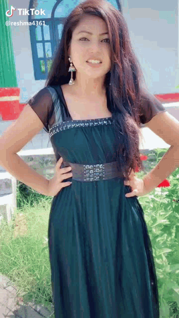 a woman in a green dress is posing for a tiktok