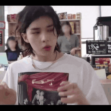 a young man wearing a white t-shirt with a picture of a man and woman on it .