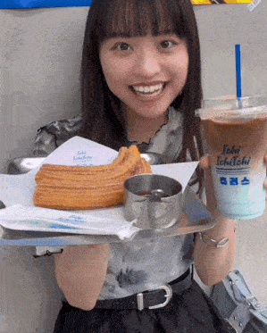 a woman holding a churro and a drink that says ichi