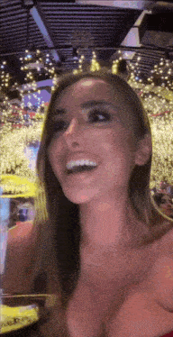 a woman in a red dress is smiling in front of a christmas tree