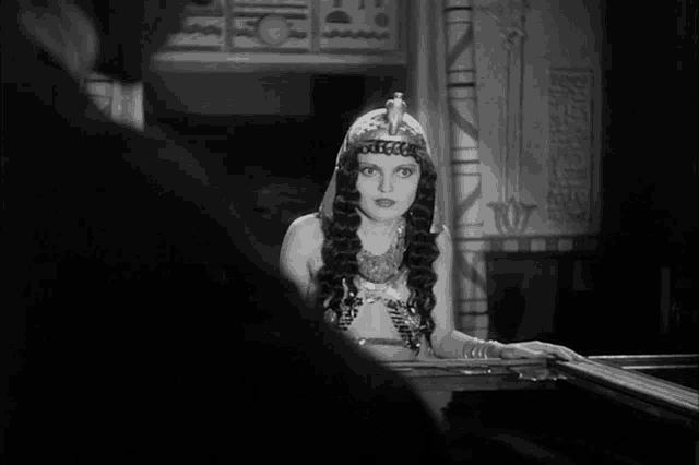 a black and white photo of a woman wearing a tiara