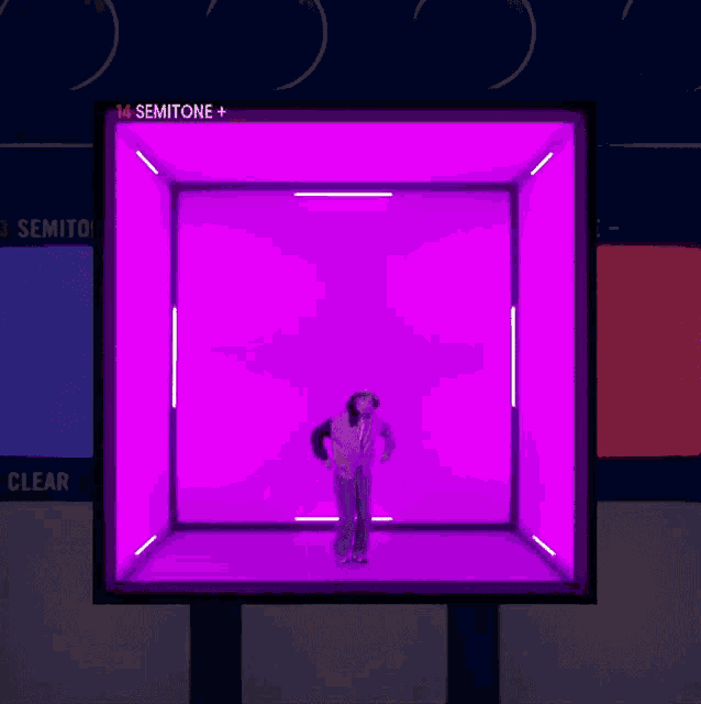 a person is standing in a purple box with the number 14 semitone + on the top