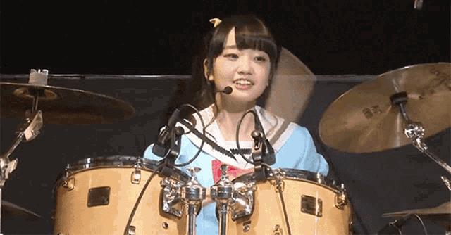 a girl playing a drum set with a sabian cymbal in the background