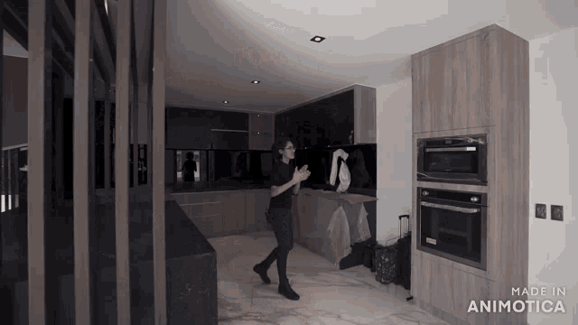 a man standing in a kitchen with the words made in animatica on the bottom right
