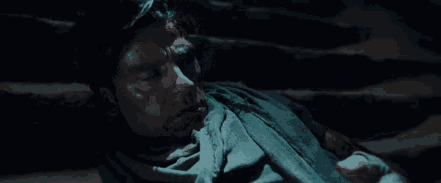 a man with a scarf around his neck is laying on the ground