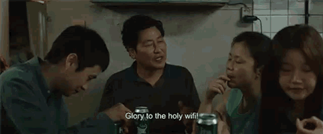 a group of people are sitting around a table drinking beer and eating food .