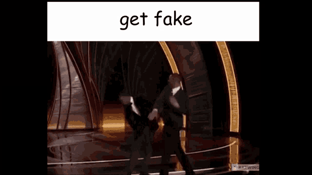 two men are fighting on a stage with the words get fake written on the bottom .