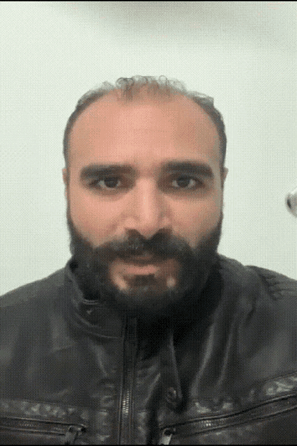 a man with a beard is wearing a black jacket