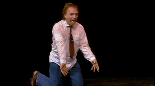 a man in a white shirt and tie is kneeling down on the floor