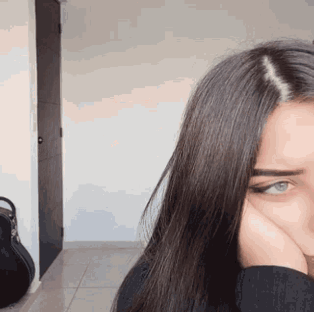 a woman covering her face with her hand in a room