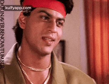 a close up of a man wearing a red headband and a gold chain .