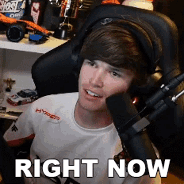 a young man wearing headphones is sitting in front of a microphone with the words right now above him