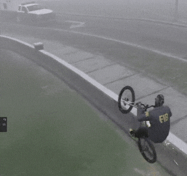 a person is falling off a bicycle on a foggy day