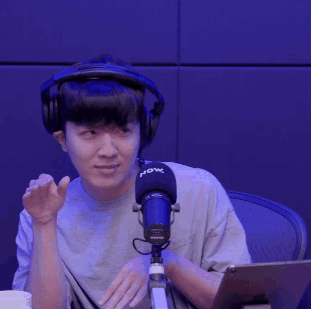 a man wearing headphones and a microphone with the word now on it