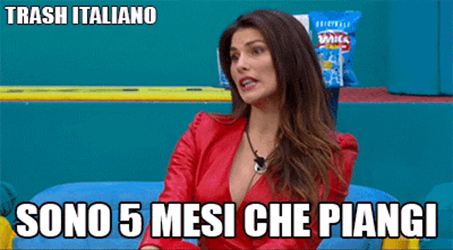 a woman in a red dress sits on a blue couch with trash italiano written on the bottom