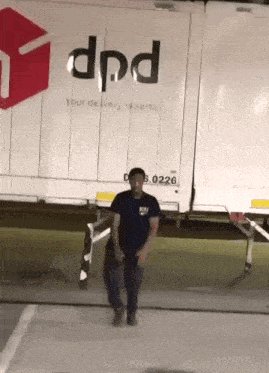 a man is dancing in front of a dpd delivery truck