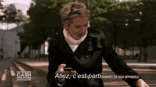 a woman is holding a cell phone and says " allez c 'est parti "