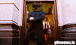a man in a suit with a bear head is standing in a doorway with gifmemes.jo written on the bottom