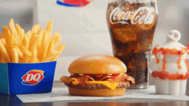 a hamburger french fries and a glass of coca cola are on a table