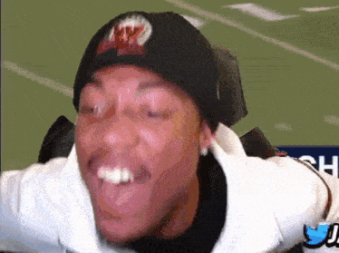 a man wearing a beanie and a white jacket making a funny face