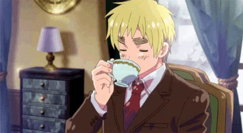 a man in a suit and tie is drinking from a tea cup