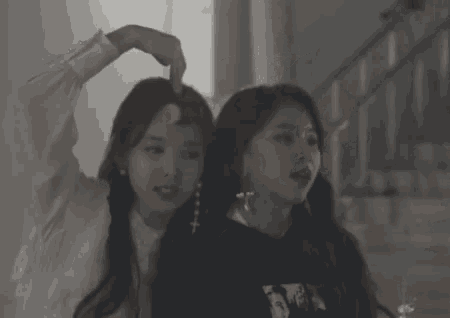 a couple of girls are standing next to each other in a room .