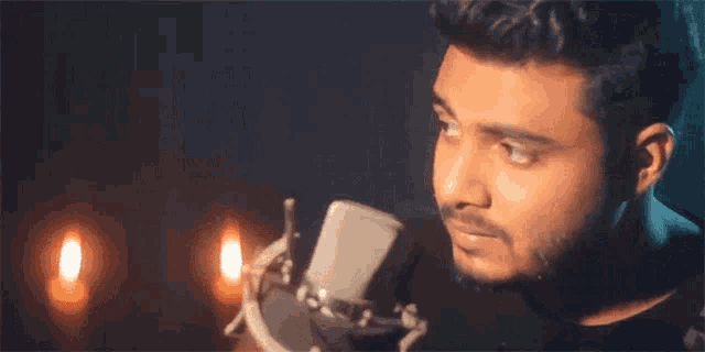 a man is singing into a microphone in a dark room .