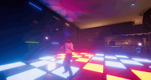 a man in a white shirt is dancing on a dance floor in a dark room