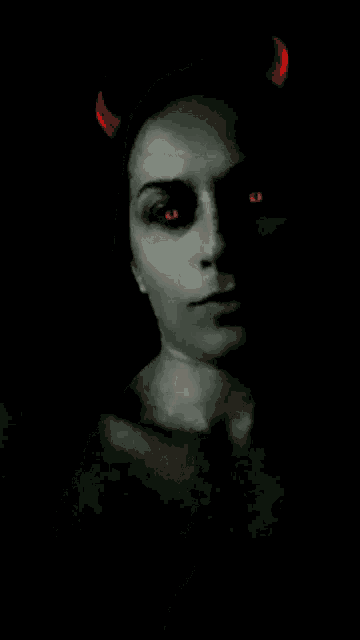 a woman with devil horns and red eyes is making a silence gesture