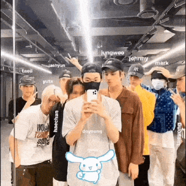 a group of young men are standing next to each other in front of a mirror .