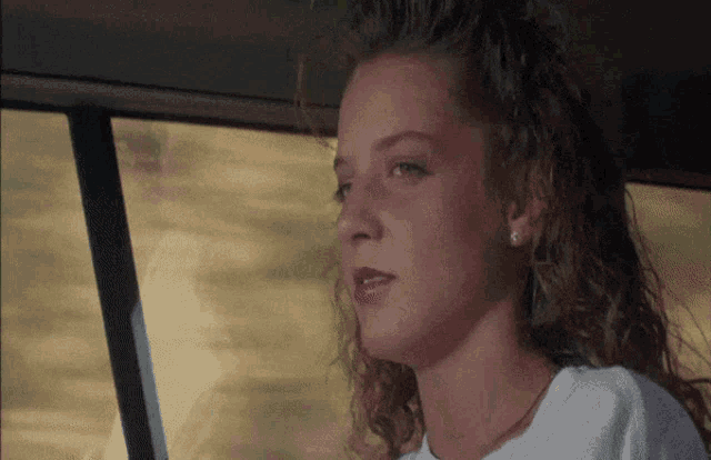 a close up of a woman 's face with a white shirt on