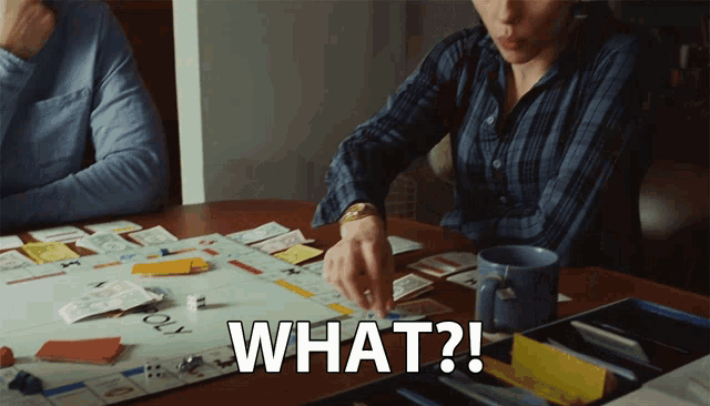 a person playing a board game with the words what on the table