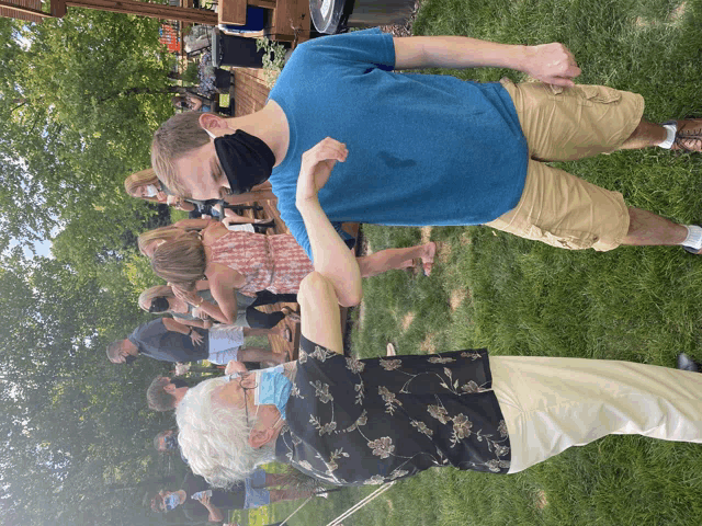 a man wearing a mask is dancing with a woman